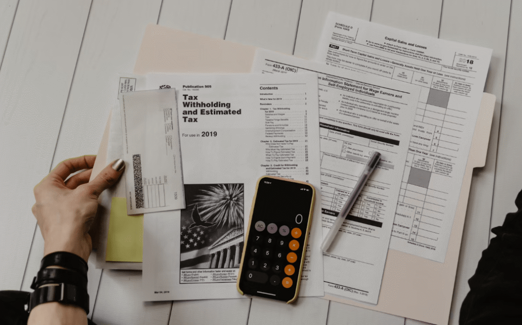 a hand holding a pen and a check and a calculator